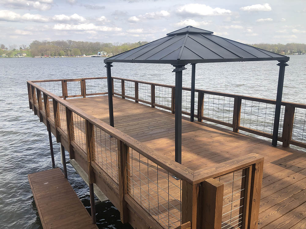brown stained deck on lake with black umbrella structure