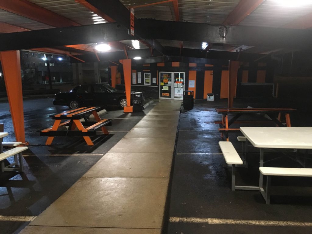 restaurant exterior with picnic tables and black car